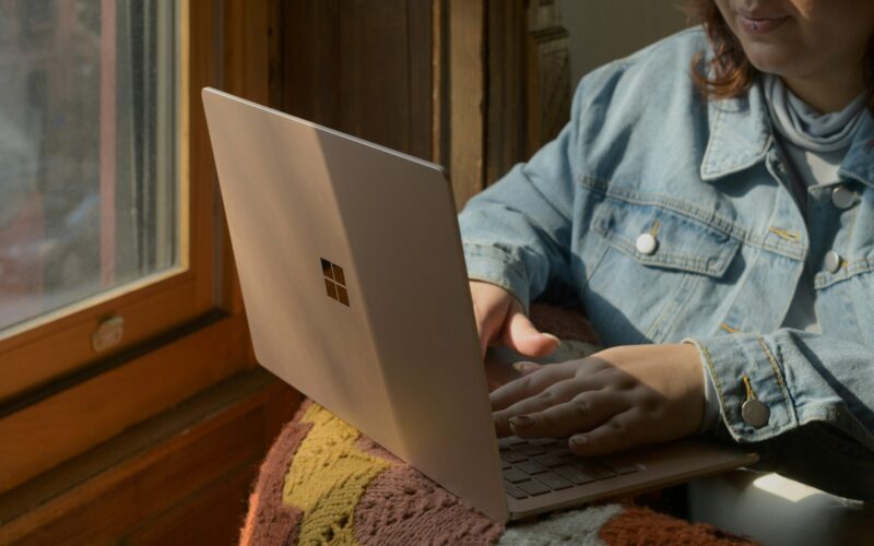 a woman sitting in a chair using a laptop computer